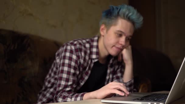 Влюбленный молодой человек смотрит на ноутбук и улыбается. Парень влюбляется — стоковое видео