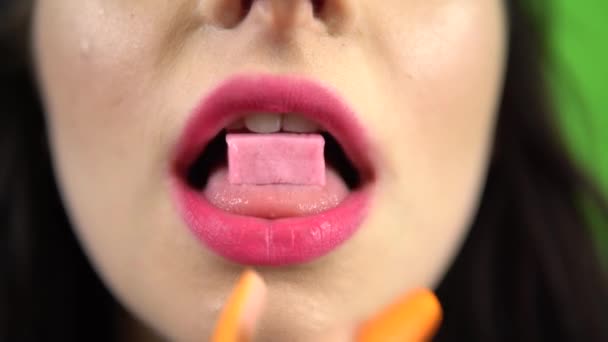 Lány tett rózsaszín buborék szájon rágógumi 4k közelkép rózsaszín ajkak zöld képernyő — Stock videók