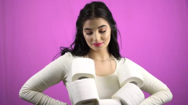 Молодая женщина с туалетной бумагой улыбка, фиолетовый фон коронавируса паника покупка — стоковое видео