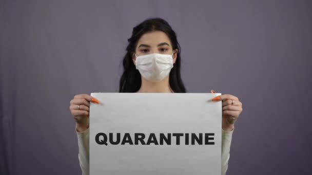 Mujer con máscara médica sosteniendo signo de cuarentena coronavirus covid-19 pandemia — Vídeo de stock