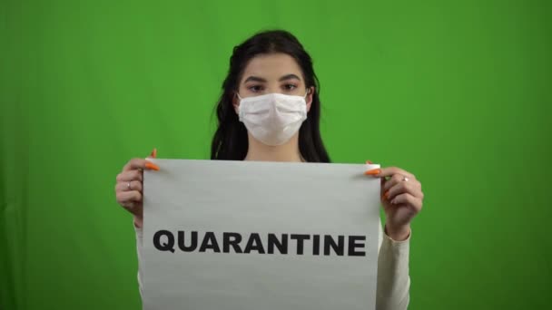 Το κορίτσι με την ιατρική μάσκα κρατάει μια πινακίδα καραντίνας στην πράσινη οθόνη. Τραγούδι COVID-19. — Αρχείο Βίντεο
