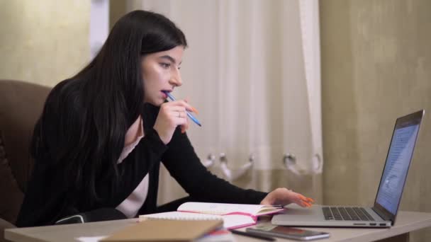 Студентська дівчина з ноутбуком, що вивчає онлайн нотатки домашнє завдання Інтернет-урок позаштатний — стокове відео