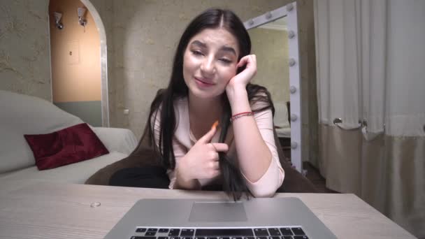A fiatal lány videóbeszélgetéssel kommunikál. Szerelembe esni, mosolyogni, webkamerát nézni — Stock videók