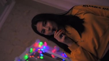 Genç kız sigara içiyor, elektronik sigara içiyor, sigara içiyor, yavaş çekim yapıyor, dikey video çekiyor.