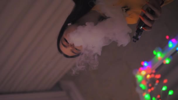 Молодая девушка курит vape, vaping, электронные sigarette замедленного движения вертикальное видео — стоковое видео