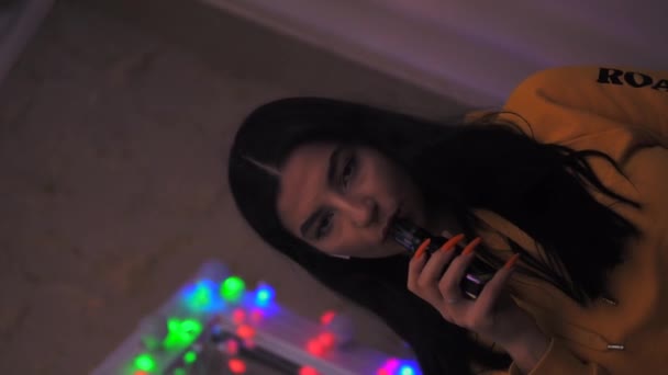 Menina fumando vape, inalando um cigarro eletrônico, fumaça de vape, câmera lenta 4x — Vídeo de Stock