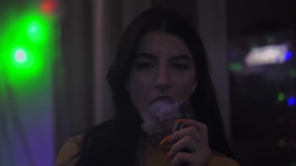 Девушка курит vape, курит электронную сигарету, напротив зеркала замедленной съемки — стоковое видео