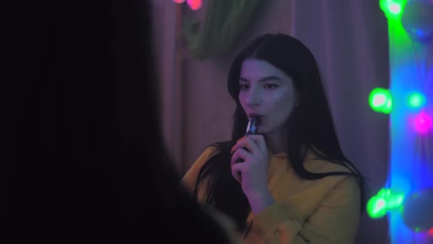 Seksi, tüttüren kız aynaya, e-sigaraya bakıyor. — Stok video