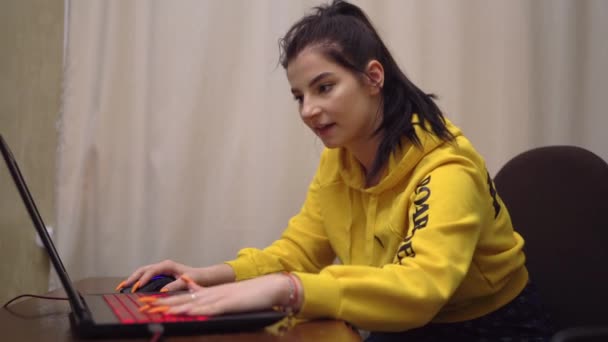 Chica joven jugador jugando videojuego en línea en el ordenador portátil, juego emocional, ganador — Vídeo de stock