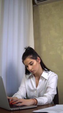 Genç ofis çalışanı dizüstü bilgisayarda yazıyor, genç iş kadını, sekreter