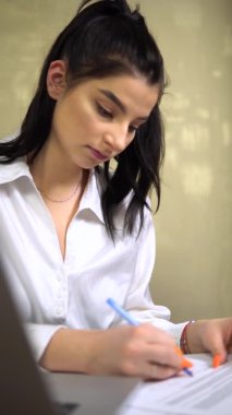 Not alan genç iş kadını, sekreter, ofis çalışanı formları dolduruyor.