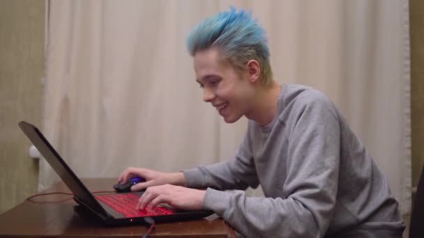 Gamer jugando juego de ordenador en línea, sonriendo, ganando, centrado en el juego — Vídeos de Stock