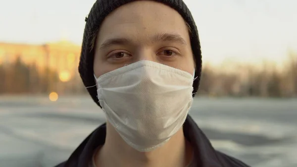 Sokak portresi Coronavirus 'ta tıbbi koruyucu maskeli genç öğrenci.