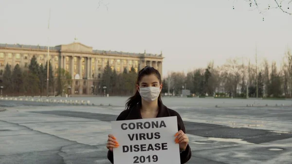Sokakta boş alanda COVID-19 posteri olan bir kız, karantina, koronavirüs, maske