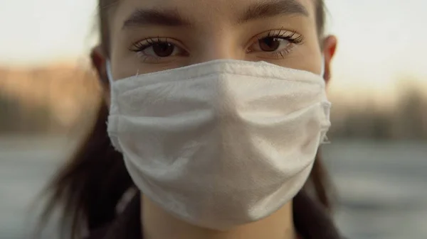 Kadın, boş şehir caddesi köşesi covid-19 'da koruyucu maske takıyor.