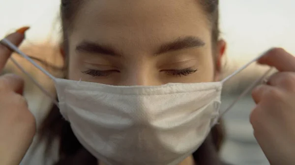 Korumacı tıbbi maske takan genç bir kadının portresi boş cadde, covid-19