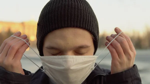 Boş caddede koruyucu maske takan genç adam, koronavirüs karantinasında.