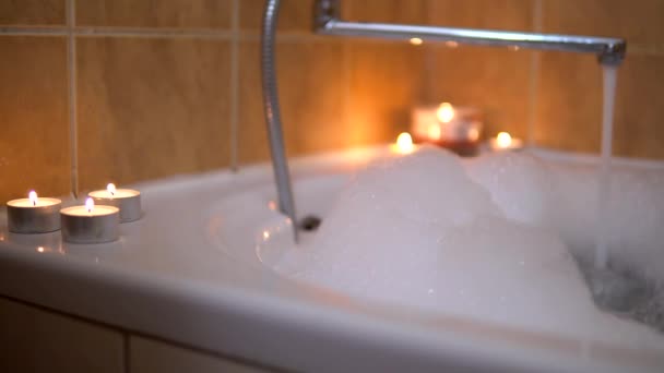 Mulher tomar espuma de balbucio banho com velas, atmosfera romântica, casa à noite — Vídeo de Stock