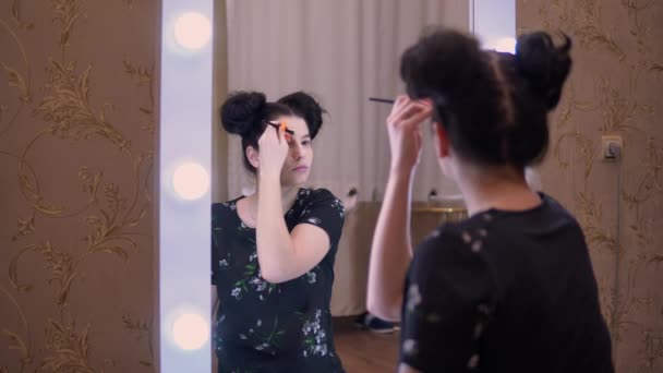 Mädchen geschminkt, Blick auf großen Visage-Spiegel, Augenbrauen, Beauty-Bloggerin — Stockvideo