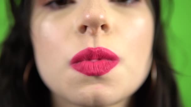 녹색 화면에서 핑크 버블 껌을 불며 핑크 립스틱을 빨아들이는 섹시 한 소녀 — 비디오