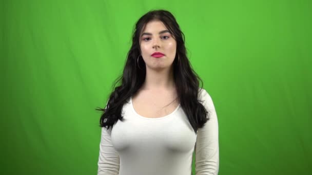 Young woman blowing pink bubble gum on green screen slow motion — Stock Video