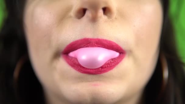 Flicka blåser tuggummi, rosa läppstift, tuggummi godis på grön skärm — Stockvideo