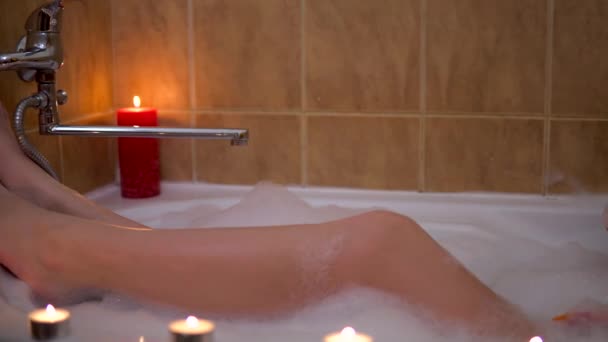 Young woman relaxing in babble bath, long legs, playing with foam, romantic — Stock Video