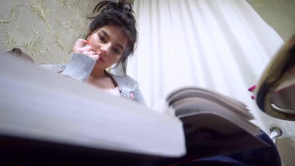 Young woman reading book at cozy living room self-education, home comfort — Stock Video