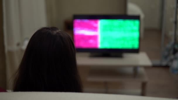Жінка на дивані дивиться телевізор "Зелений екран". Розслабляючий вечір вдома — стокове відео