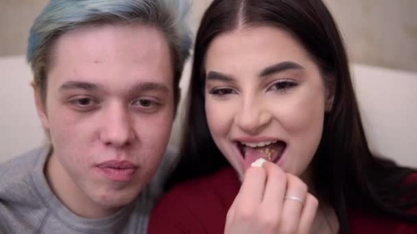 Słodkie romantyczny para oglądanie TV film portret zbliżenie jedzenie popcorn śmiech — Wideo stockowe