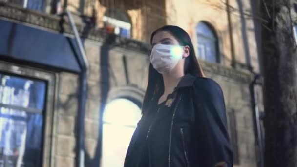 Mulher andando em máscara protetora na rua ensolarada coronavírus covid-19 quarentena — Vídeo de Stock