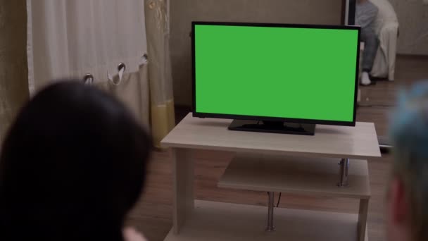 Молодая женщина на кашле смотреть телевизор зеленый экран макет расслабляющий в уютном доме — стоковое видео