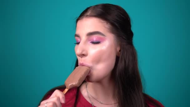 Mulher feliz sorrindo e comendo lambendo chocolate sorvete retrato de perto — Vídeo de Stock