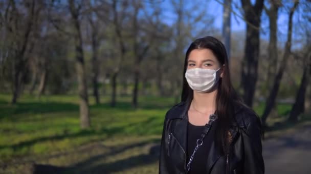 Mujer caminando en el parque en máscara médica protectora, coronavirus, covid-19 — Vídeos de Stock