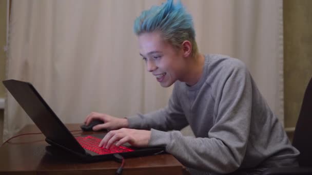 Joueur heureux souriant excité jouant et gagnant dans le jeu vidéo d'ordinateur en ligne 