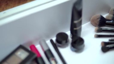 Makyaj malzemesi, göz farı paleti, rimel ve aynadaki ruj.