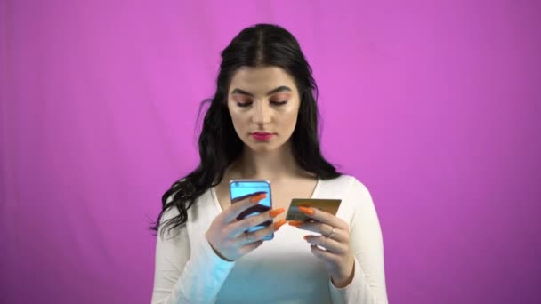 Красотка, совершающая онлайн-оплату с помощью смартфона кредитной картой — стоковое видео