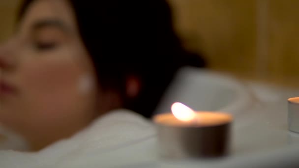 Woman relaxing in bath with candles, romantic evening, bubble bath — Stock Video