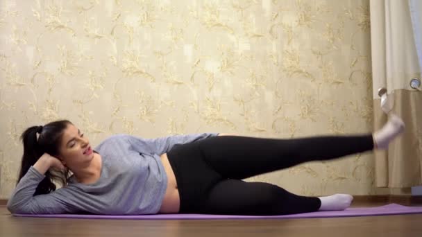 Молодая ленивая женщина делает спортивные упражнения дома, похудеть — стоковое видео