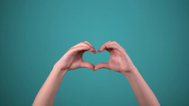 Hand show heart by fingers, isolated on blue background — Stock Video