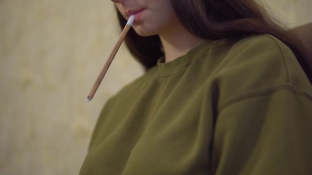 Καλλιτέχνης κρατώντας μολύβι στο στόμα, σχεδιάζει σε μπλοκ, ζωγράφος — Αρχείο Βίντεο