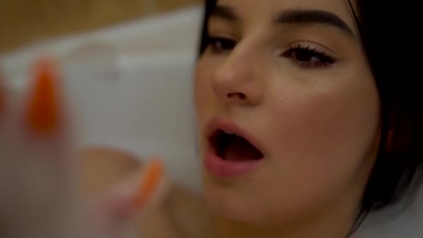Menina de beleza brincando com espuma no banho de bolhas, relaxando em casa, banheiro acolhedor — Vídeo de Stock