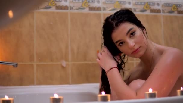 Молодая красавица в ванной смотрит на фотопортрет — стоковое видео