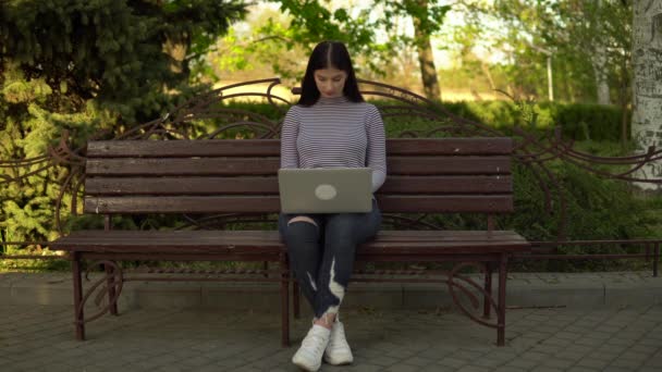 Femeie care lucrează în aer liber, freelancer folosind laptop în parc oraș — Videoclip de stoc