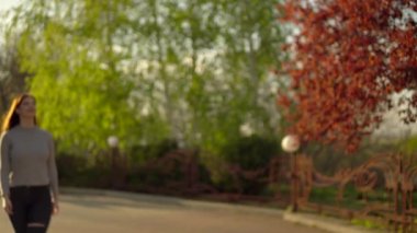 Gün batımında parkta yürüyen kadın