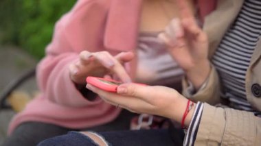 Cep telefonlu iki çekici kız, parkta yürüyor, arkadaşlık kavramı.