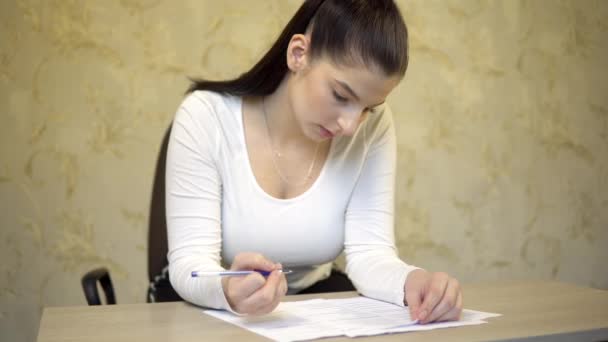 Mujer joven firmando documentos, haciendo exámenes, escribiendo en forma — Vídeos de Stock