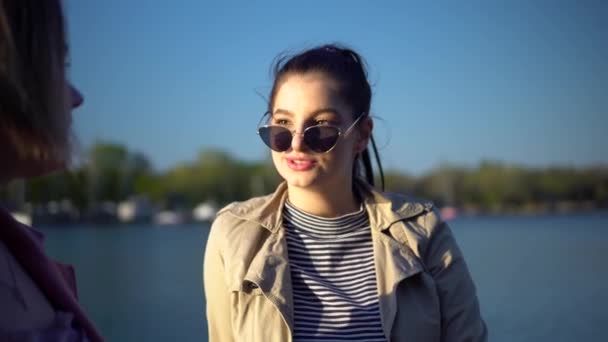 Mladé ženy mluví na nábřeží, šťastně se usmívají — Stock video