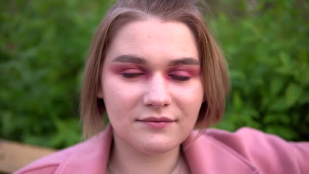 Junge Frau mit Kurzhaarschnitt blickt in die Kamera — Stockvideo