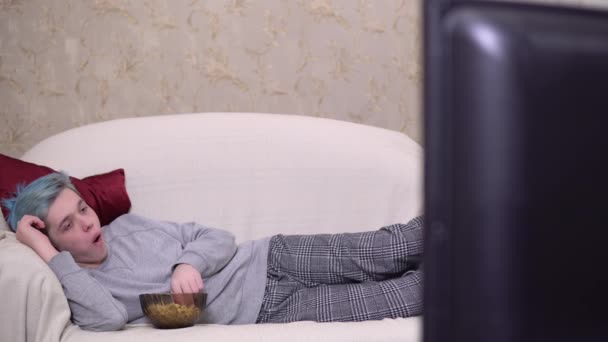 Мужчина отдыхает, ест попкорн и смотрит телевизор, кино дома — стоковое видео